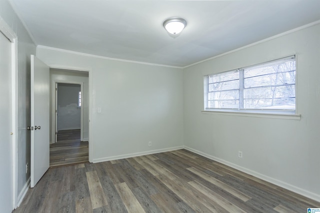 spare room featuring crown molding and dark hardwood / wood-style flooring