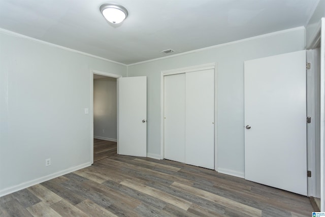 unfurnished bedroom featuring dark hardwood / wood-style floors, a closet, and ornamental molding