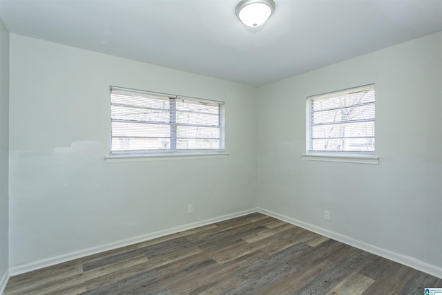 empty room with plenty of natural light and dark hardwood / wood-style floors