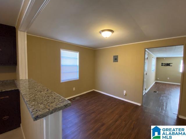 interior space with crown molding and dark wood-type flooring