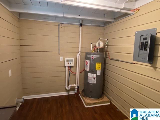 utility room featuring electric panel and electric water heater