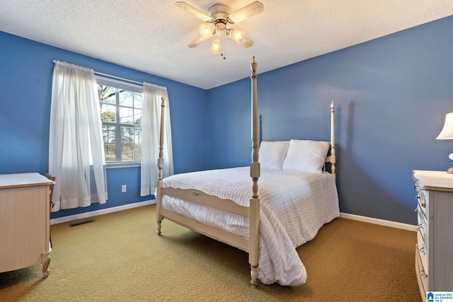 carpeted bedroom with ceiling fan and a textured ceiling