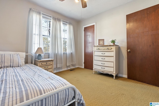 bedroom with light carpet, a textured ceiling, and ceiling fan