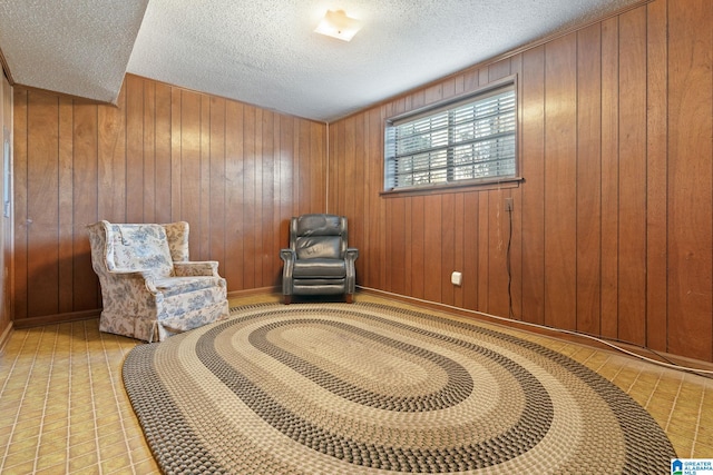 sitting room featuring wood walls and a textured ceiling