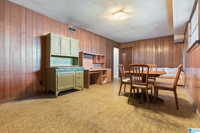 kitchen featuring green cabinets and wooden walls