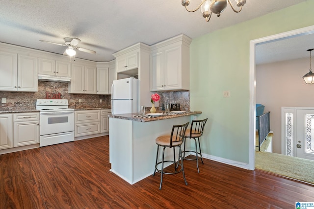 kitchen featuring kitchen peninsula, white appliances, white cabinetry, and tasteful backsplash