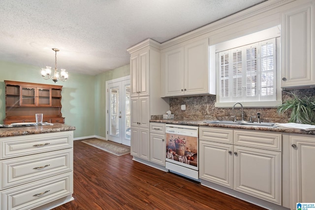 kitchen with a textured ceiling, white cabinets, decorative backsplash, sink, and white dishwasher