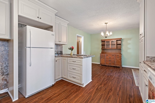 kitchen with white appliances, white cabinets, dark hardwood / wood-style floors, and kitchen peninsula