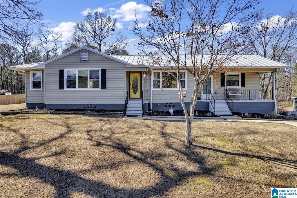 ranch-style home with covered porch and a front yard