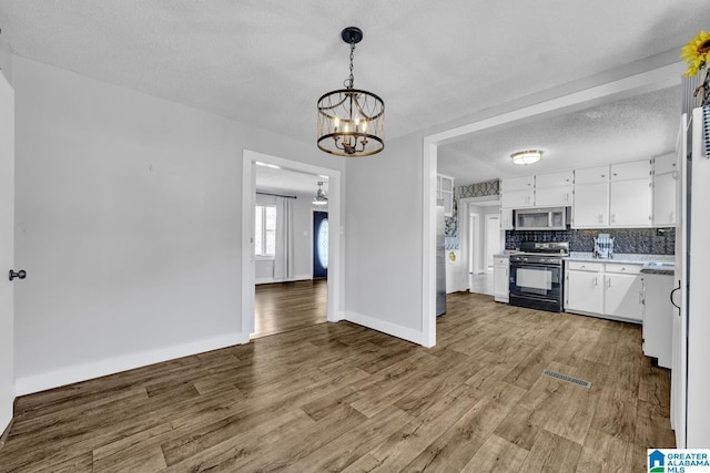 kitchen featuring decorative backsplash, light hardwood / wood-style floors, white cabinets, and stainless steel appliances