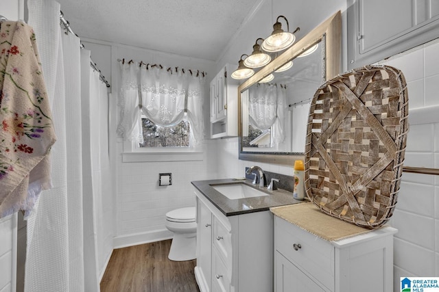 bathroom featuring vanity, toilet, a textured ceiling, and wood-type flooring