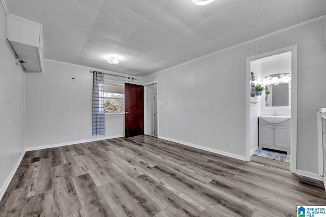 interior space featuring light wood-type flooring, ornamental molding, and sink