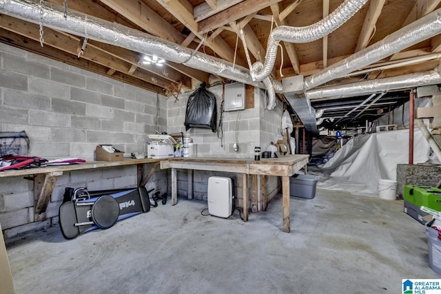 basement with electric panel and a workshop area