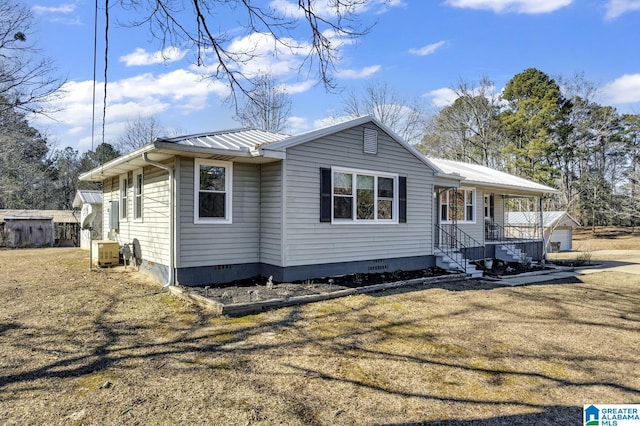 view of front of house featuring covered porch, a garage, an outdoor structure, and a front lawn