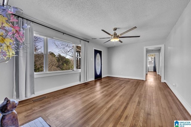 interior space featuring hardwood / wood-style flooring, ceiling fan, plenty of natural light, and a textured ceiling