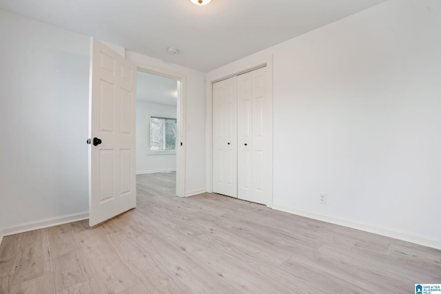 unfurnished bedroom featuring a closet and light hardwood / wood-style flooring