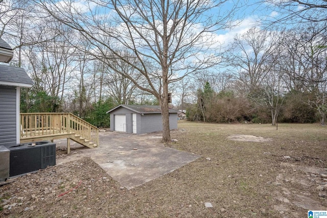 view of yard featuring a garage, an outbuilding, and central AC unit