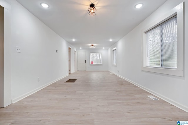 unfurnished room featuring light wood-type flooring and plenty of natural light