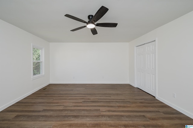 spare room featuring ceiling fan and dark wood-type flooring