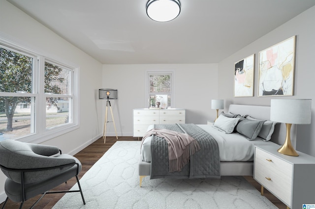 bedroom with dark wood-type flooring and multiple windows