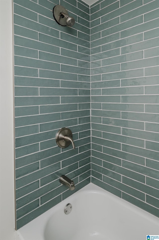 bathroom featuring tiled shower / bath