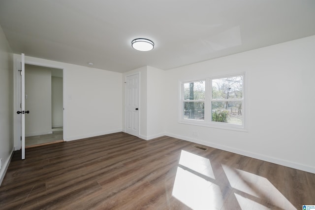 spare room featuring dark hardwood / wood-style flooring