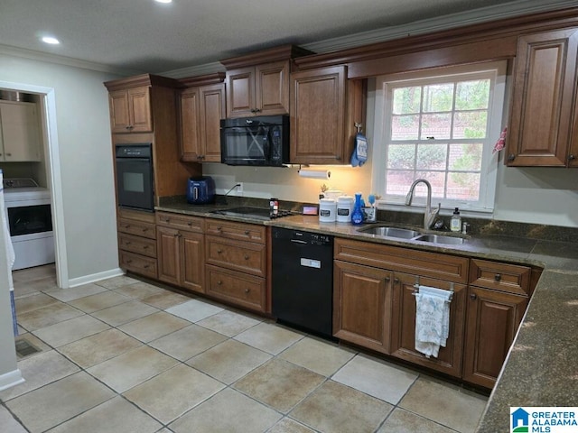 kitchen featuring black appliances, dark stone countertops, sink, light tile patterned floors, and crown molding