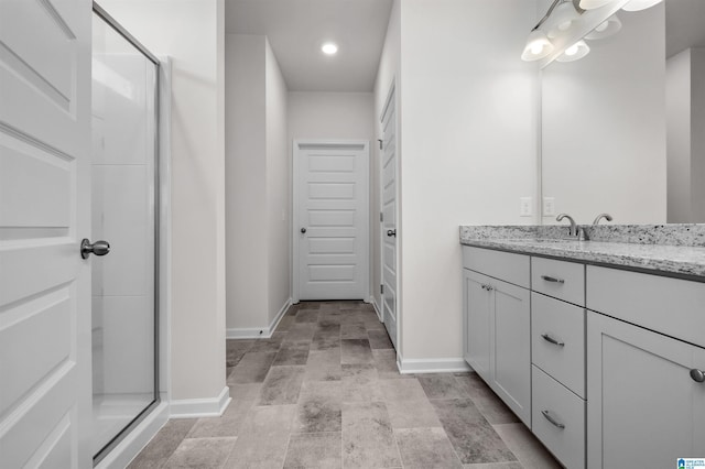 bathroom featuring vanity and a shower with door