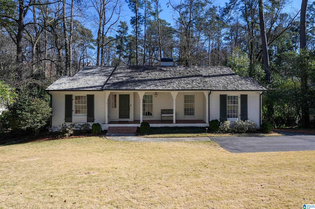 ranch-style house featuring a porch and a front lawn