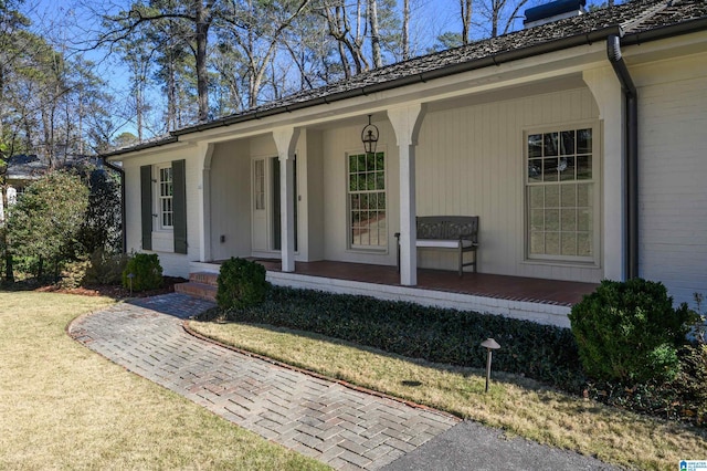 property entrance with a lawn and covered porch