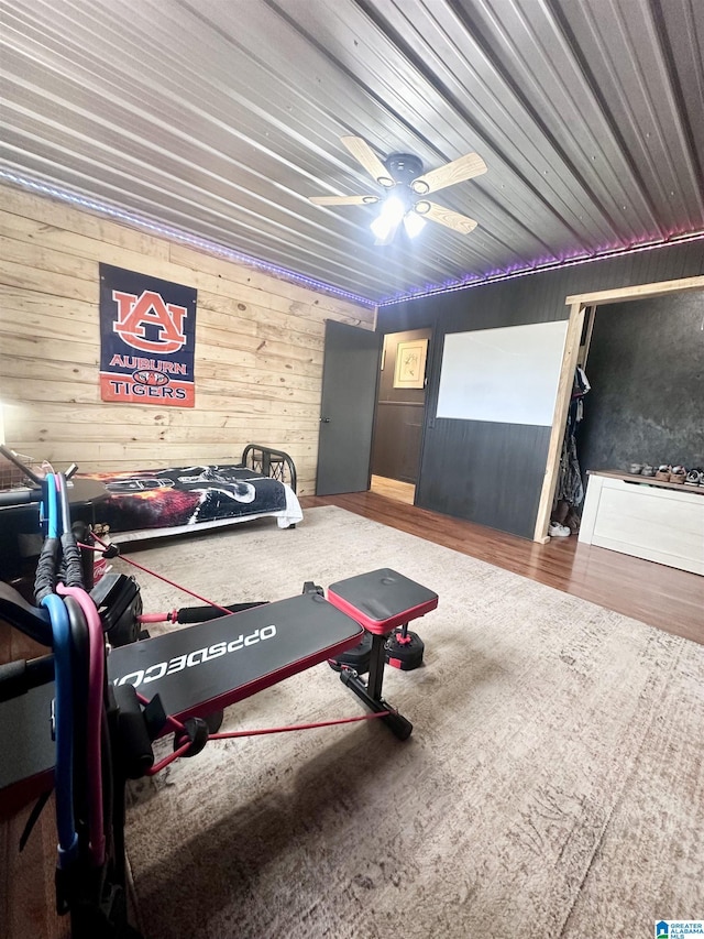 interior space featuring ceiling fan and wood walls