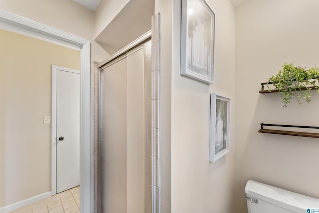 bathroom featuring a shower with shower door and toilet