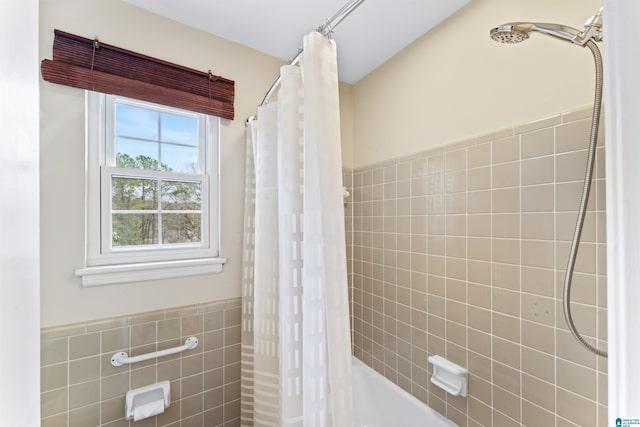 bathroom with shower / bath combo and tile walls