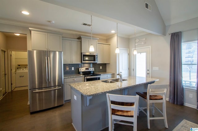 kitchen with sink, a breakfast bar area, light stone counters, a center island with sink, and appliances with stainless steel finishes