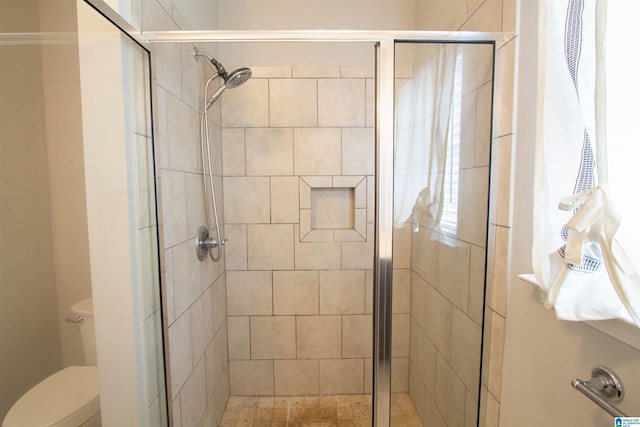 bathroom with an enclosed shower and toilet