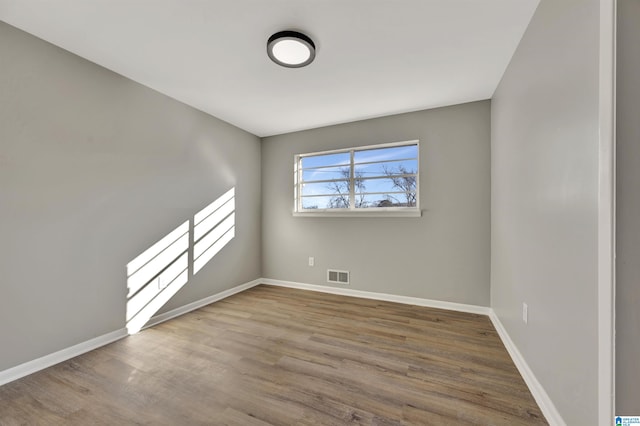 unfurnished room with hardwood / wood-style flooring