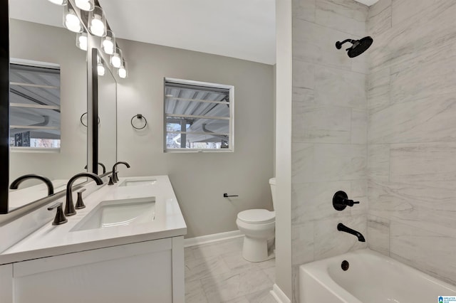 full bathroom featuring vanity, tiled shower / bath combo, and toilet