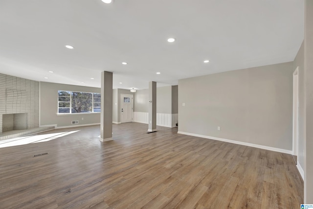 basement with a brick fireplace and light hardwood / wood-style flooring