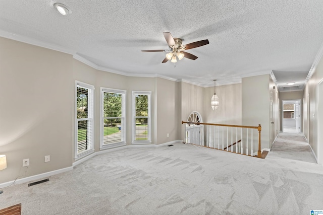 carpeted spare room featuring a textured ceiling and ornamental molding