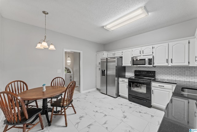 kitchen featuring white cabinetry, appliances with stainless steel finishes, and decorative light fixtures