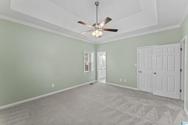 unfurnished bedroom featuring ensuite bathroom, light carpet, a closet, ornamental molding, and ceiling fan