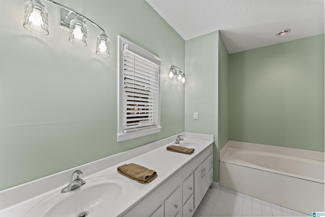 bathroom with a washtub, a textured ceiling, and vanity