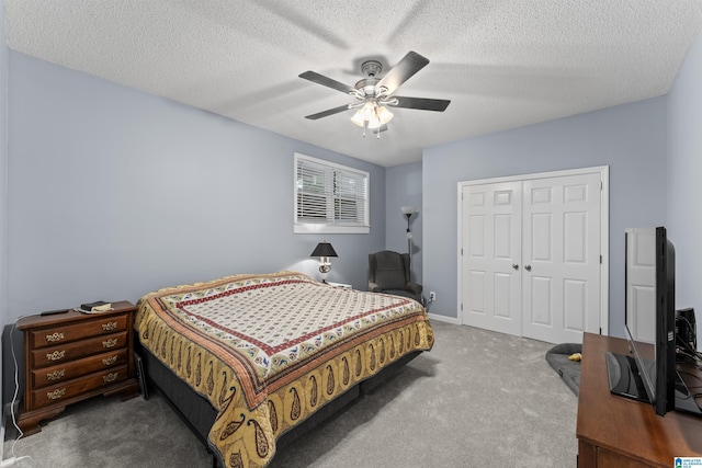 bedroom with a textured ceiling, a closet, ceiling fan, and carpet floors