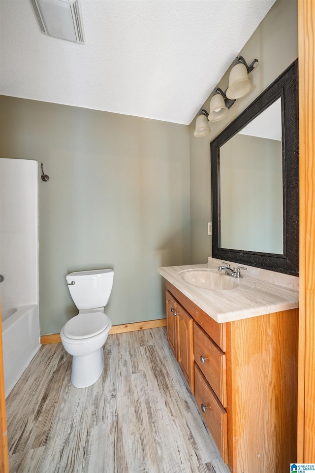 full bathroom featuring vanity, toilet, shower / bath combination, and hardwood / wood-style floors