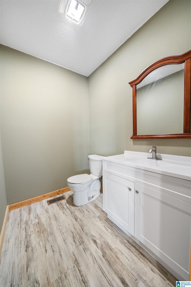 bathroom with vanity, hardwood / wood-style flooring, and toilet