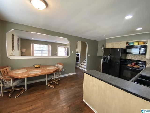 kitchen featuring black appliances, dark hardwood / wood-style flooring, and sink