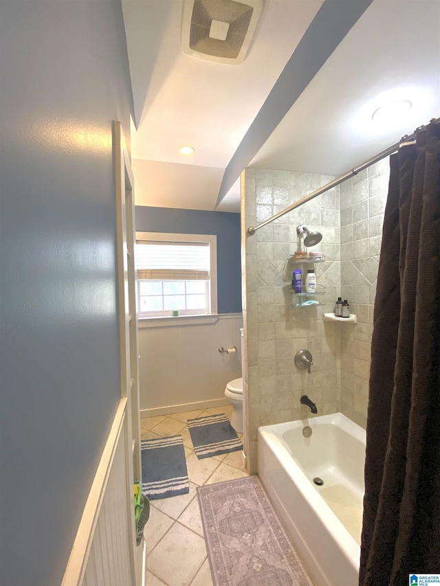 bathroom with shower / bath combo with shower curtain, toilet, and tile patterned flooring