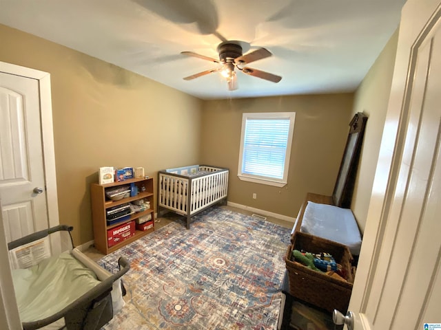 bedroom with ceiling fan and a nursery area