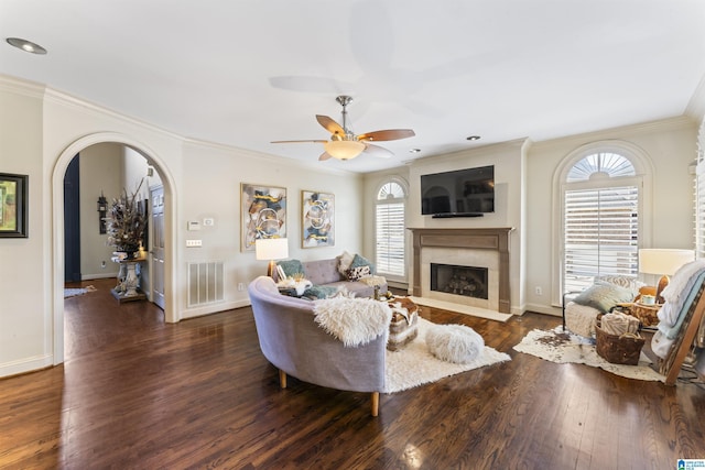 living room featuring dark hardwood / wood-style floors, crown molding, plenty of natural light, and a high end fireplace