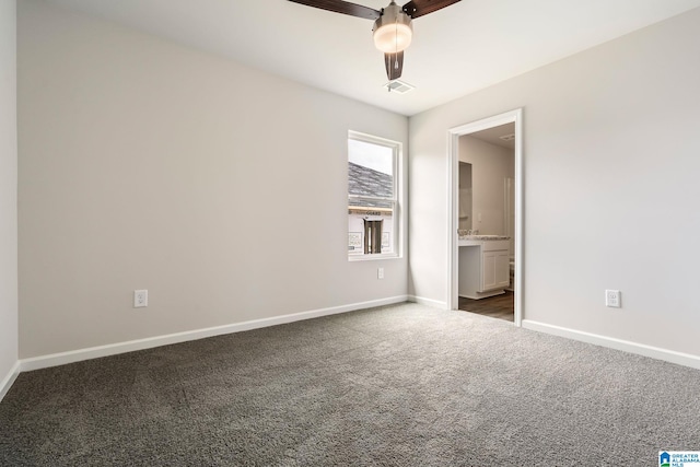 unfurnished room with ceiling fan and dark carpet